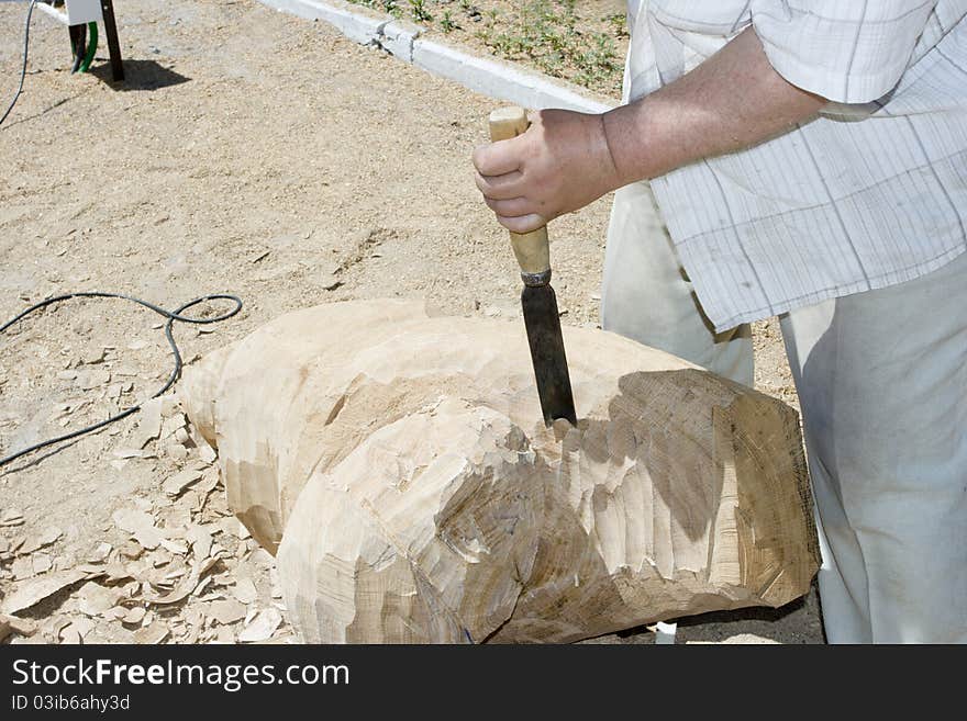 A sculptor creates a wooden sculpture