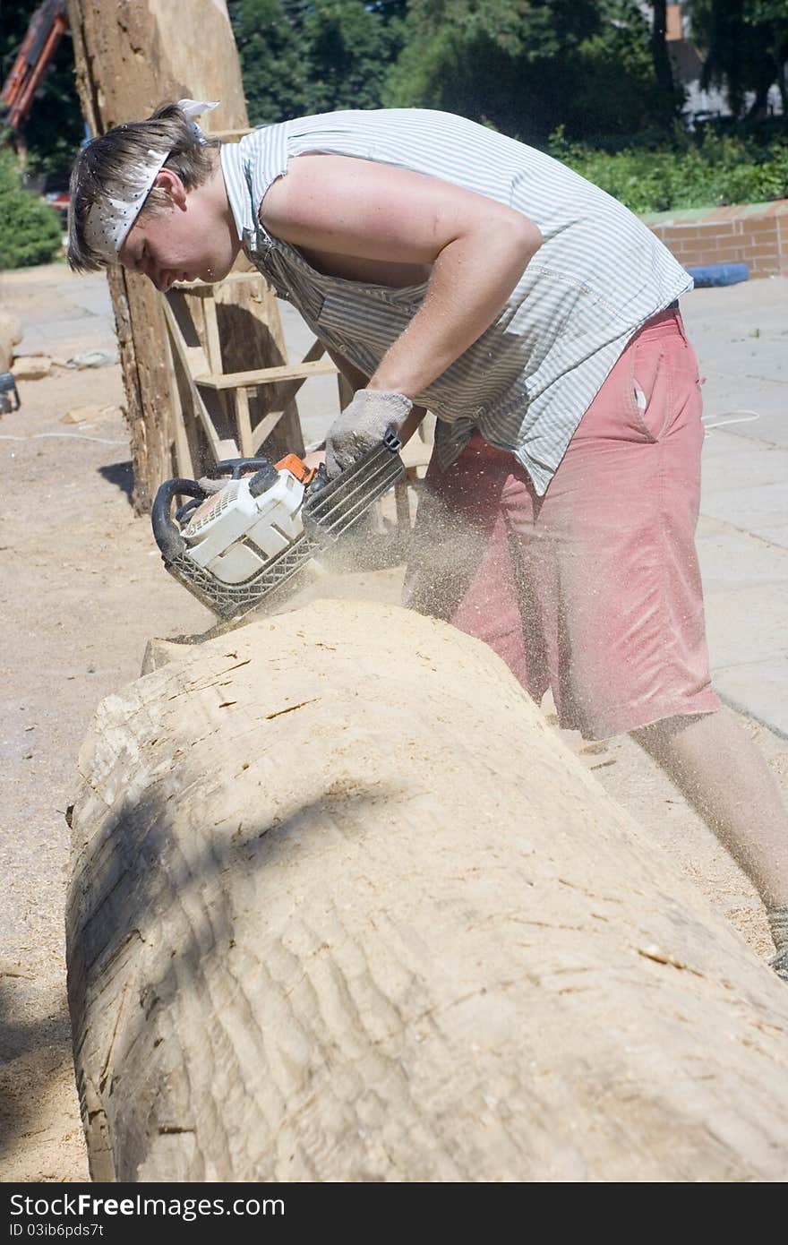 A sculptor creates a wooden sculpture