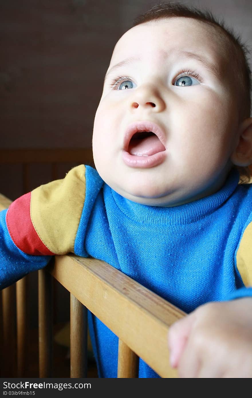 The little boy (10 months) standing on its bed and looking out of the window. The little boy (10 months) standing on its bed and looking out of the window.