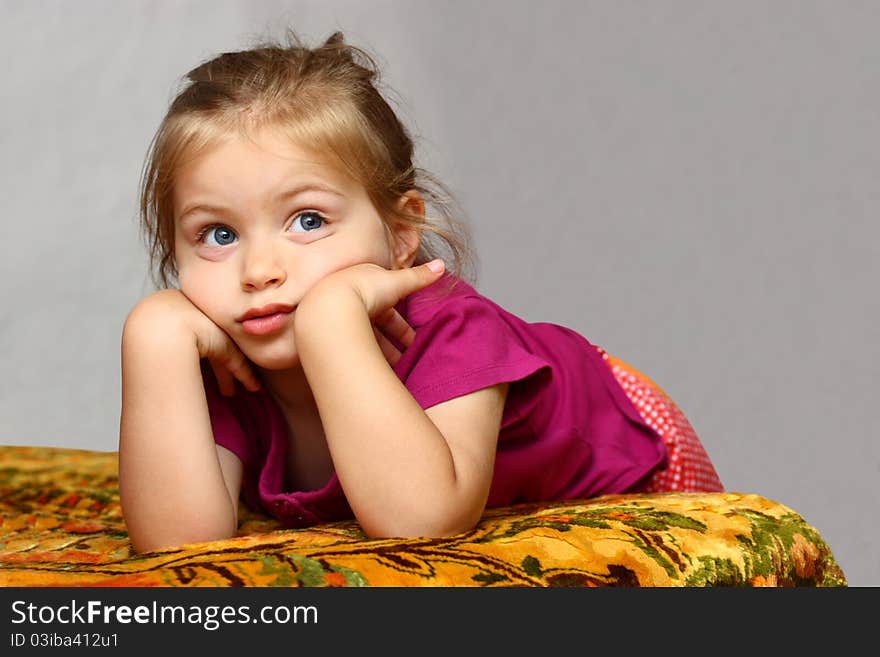 Little cute girl laying on bed with her head on her hands isolated. Little cute girl laying on bed with her head on her hands isolated