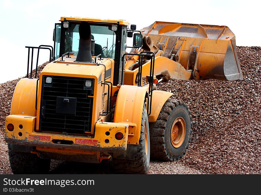 Excavator working in a quarry moving gravel