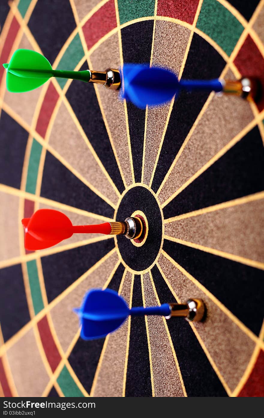 Four colorful darts at a target. Red dart hit the aim. Four colorful darts at a target. Red dart hit the aim.