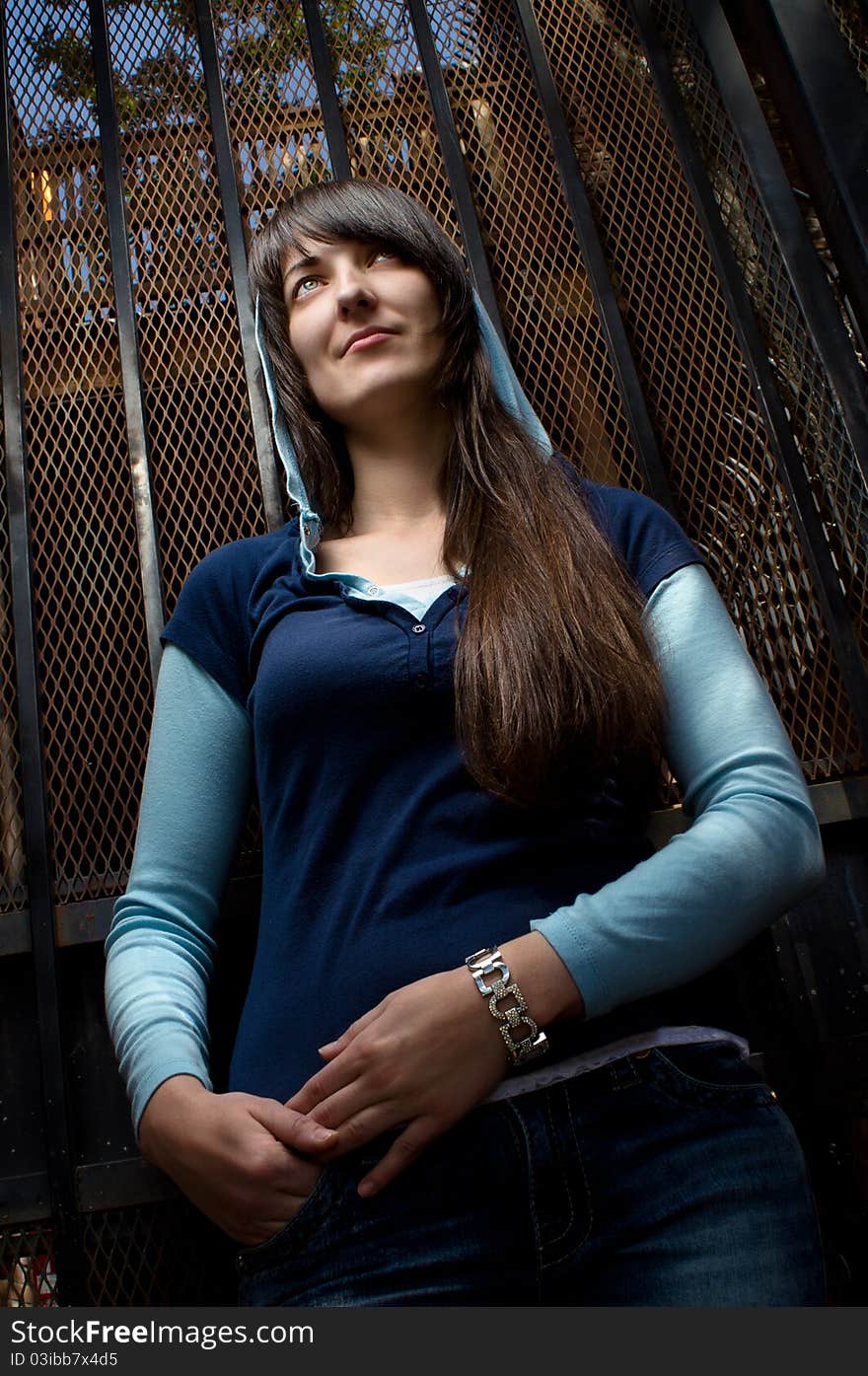 Brunette girl portrait, iron gate on background