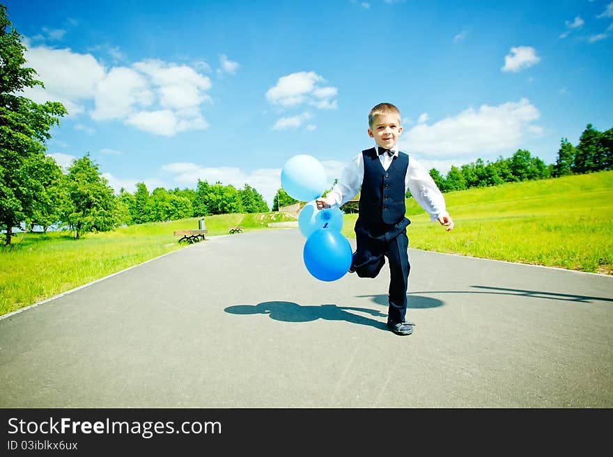 Young boy moving with balloons