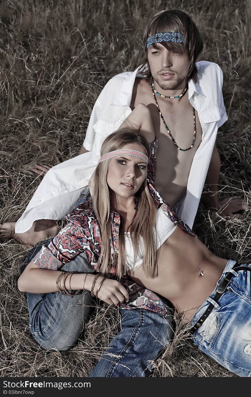 Beautiful young couple hippie posing together over picturesque landscape. Beautiful young couple hippie posing together over picturesque landscape.