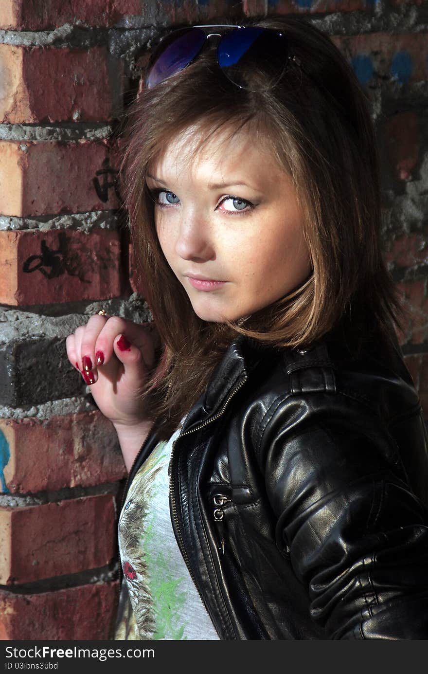 Little girl near brick wall