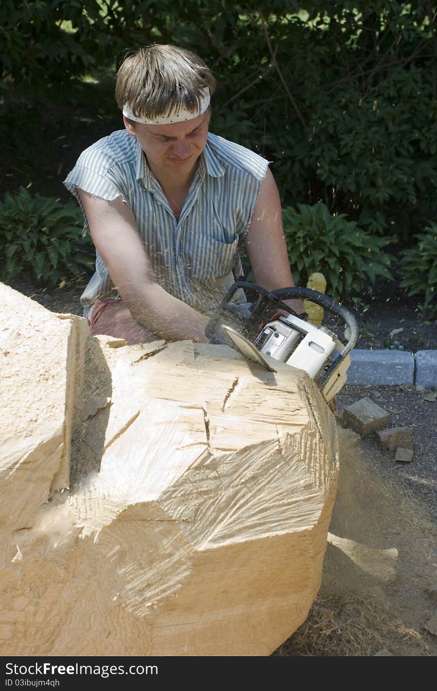 A sculptor creates a wooden sculpture