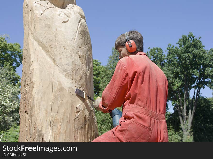 A sculptor creates a wooden sculpture