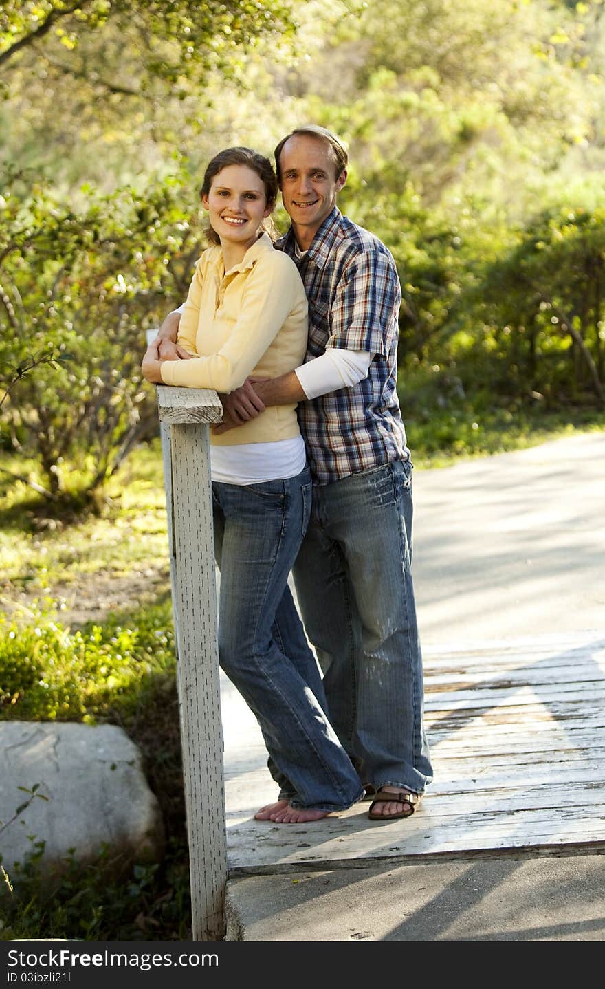 Couple standing on bridge outside, engagement pictures. Couple standing on bridge outside, engagement pictures