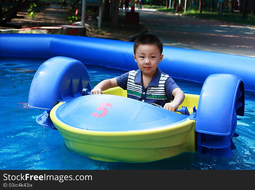 Asian boy is driving boat