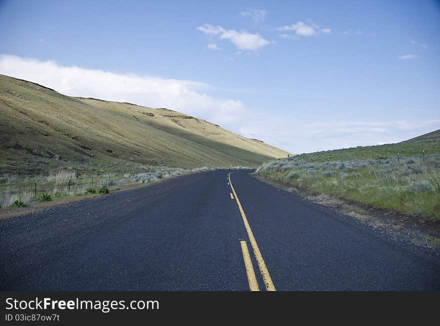 Paved rural road through arid hills