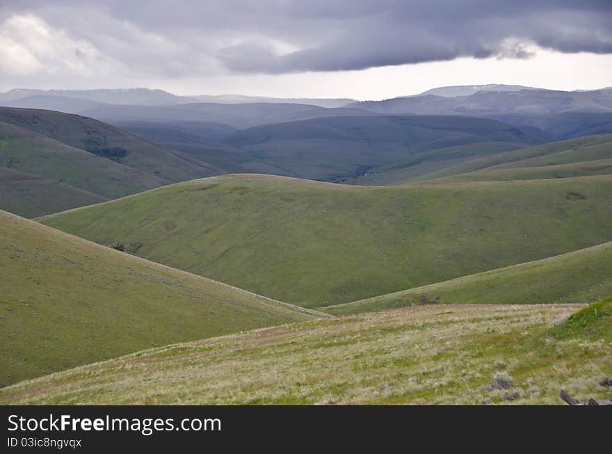 Green hills below storm clouds