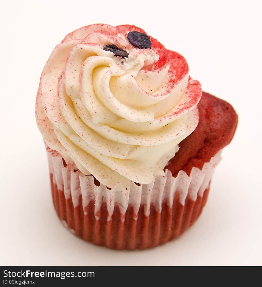 Red velvet cupcake decorated with red colored buttercream frosting against a white background.