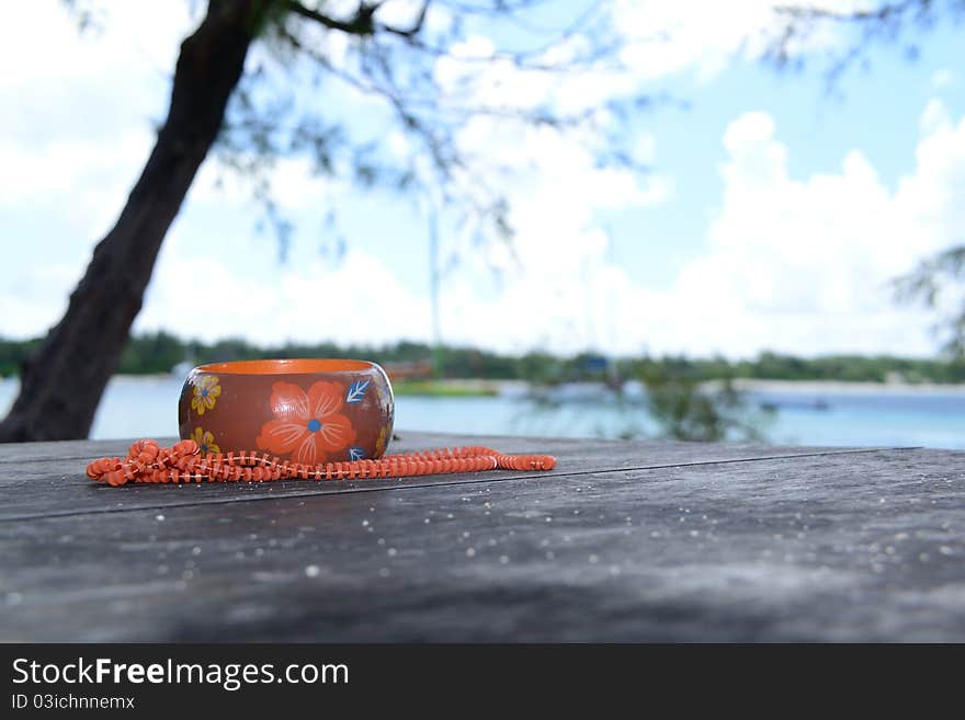 Orange and brown arm bracelet and beads on a table