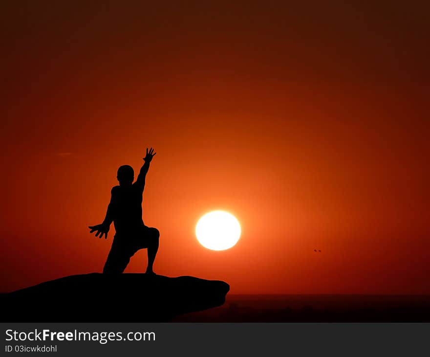 Silhouette of a man at the top of the mountain against the sky