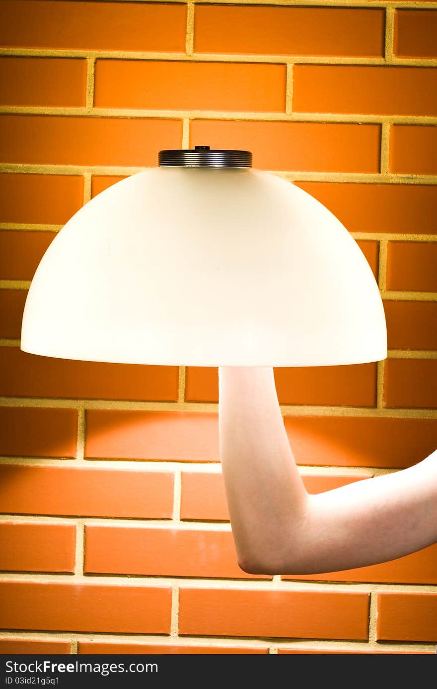 Lampshade mounted on the arm against brick wall. Lampshade mounted on the arm against brick wall