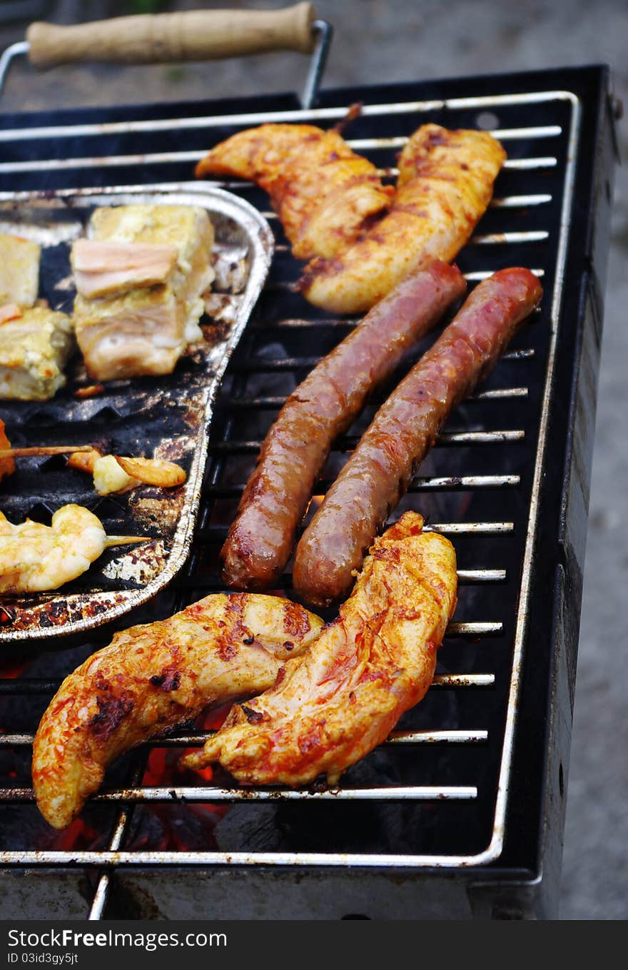 Meat, fish, bread and sausage beeing broiled on the barbecue grill. Meat, fish, bread and sausage beeing broiled on the barbecue grill.