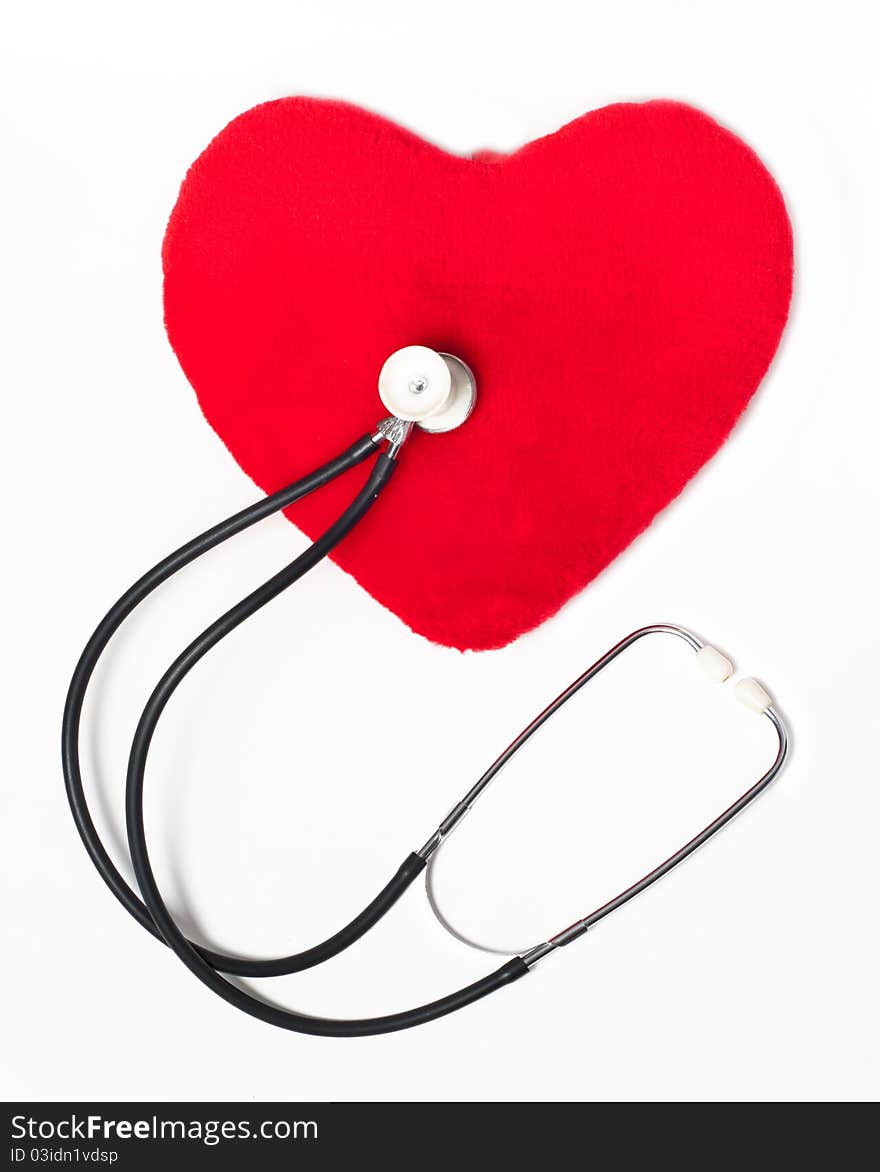 Red plush heart and stethoscope on a white background. Red plush heart and stethoscope on a white background