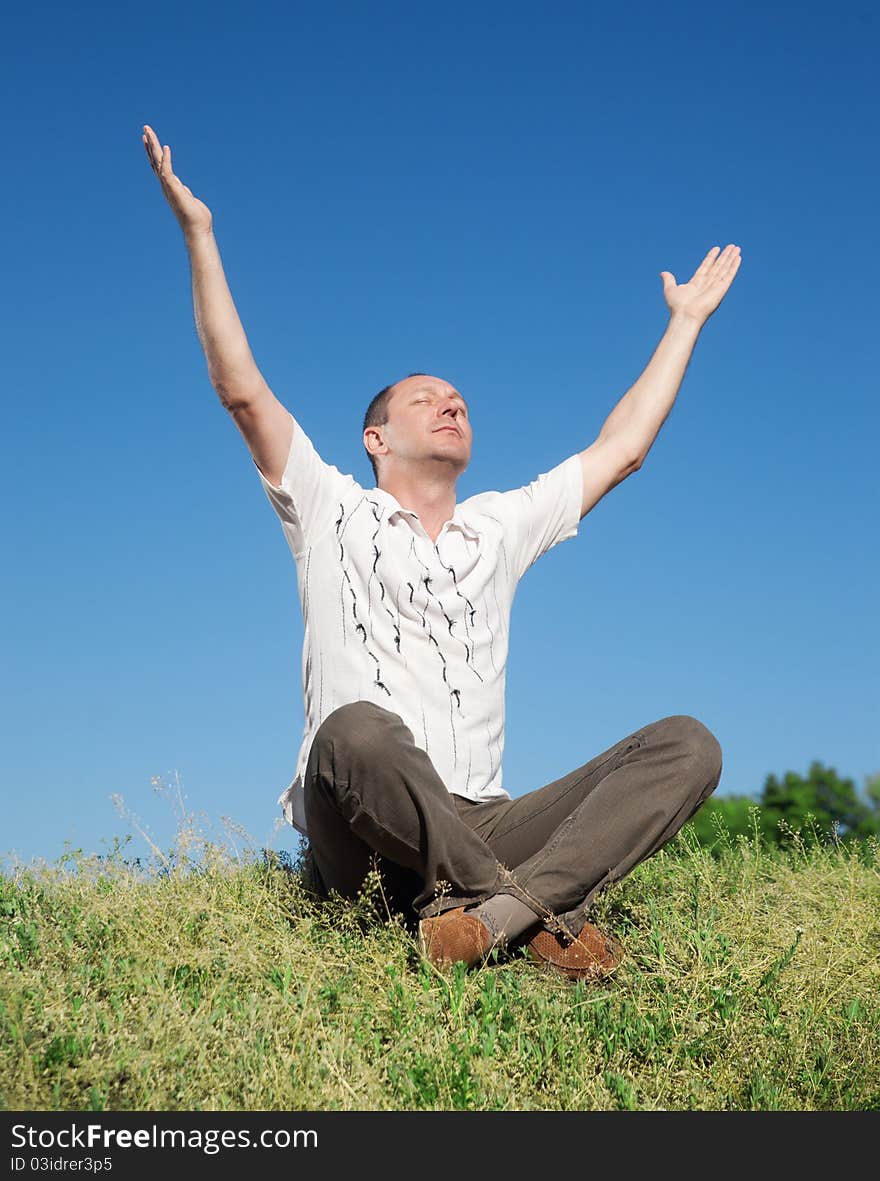 Man meditating on top of hill in park. Man meditating on top of hill in park