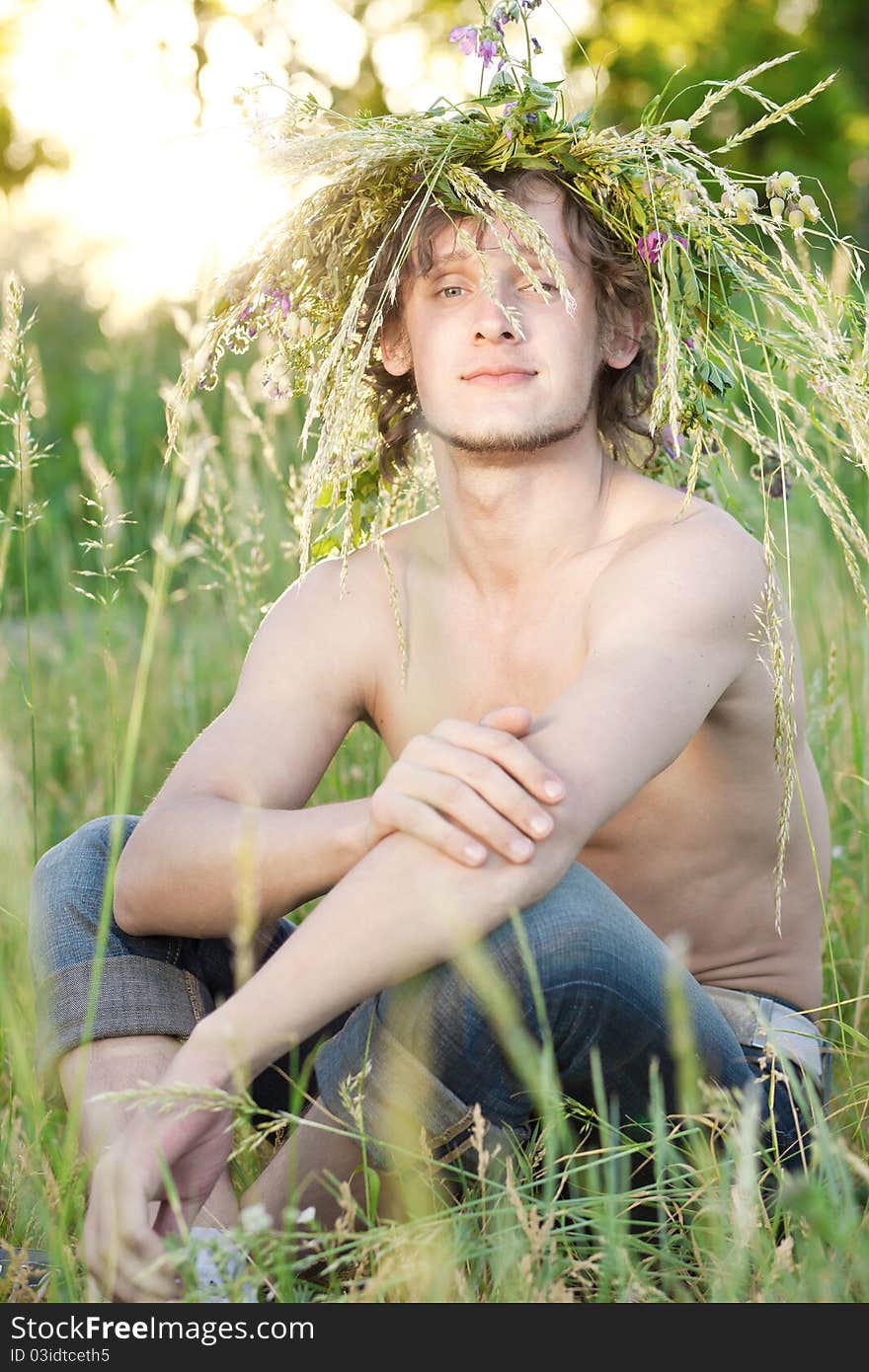 Portrait of young man that sit on grass in park. Portrait of young man that sit on grass in park