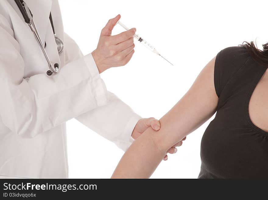 A woman doctor getting ready to give her woman patient a shot in the arm. A woman doctor getting ready to give her woman patient a shot in the arm.