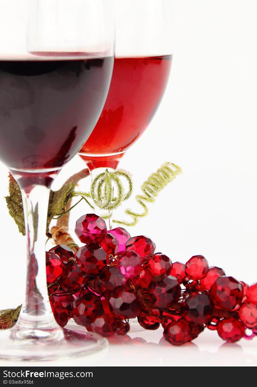 Red wine in glasses with shiny stone grape branch