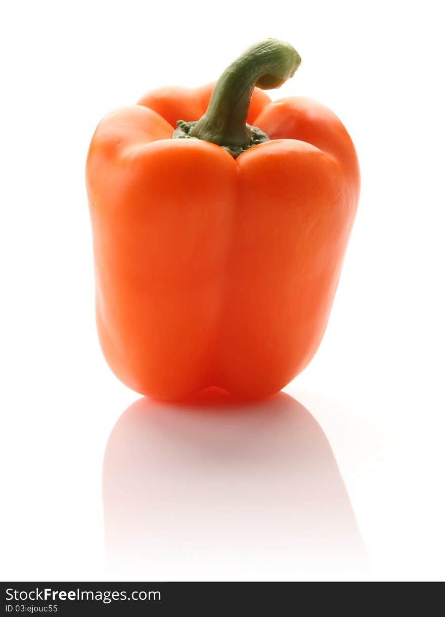 Orange pepper on white isolated background with a hint of reflection