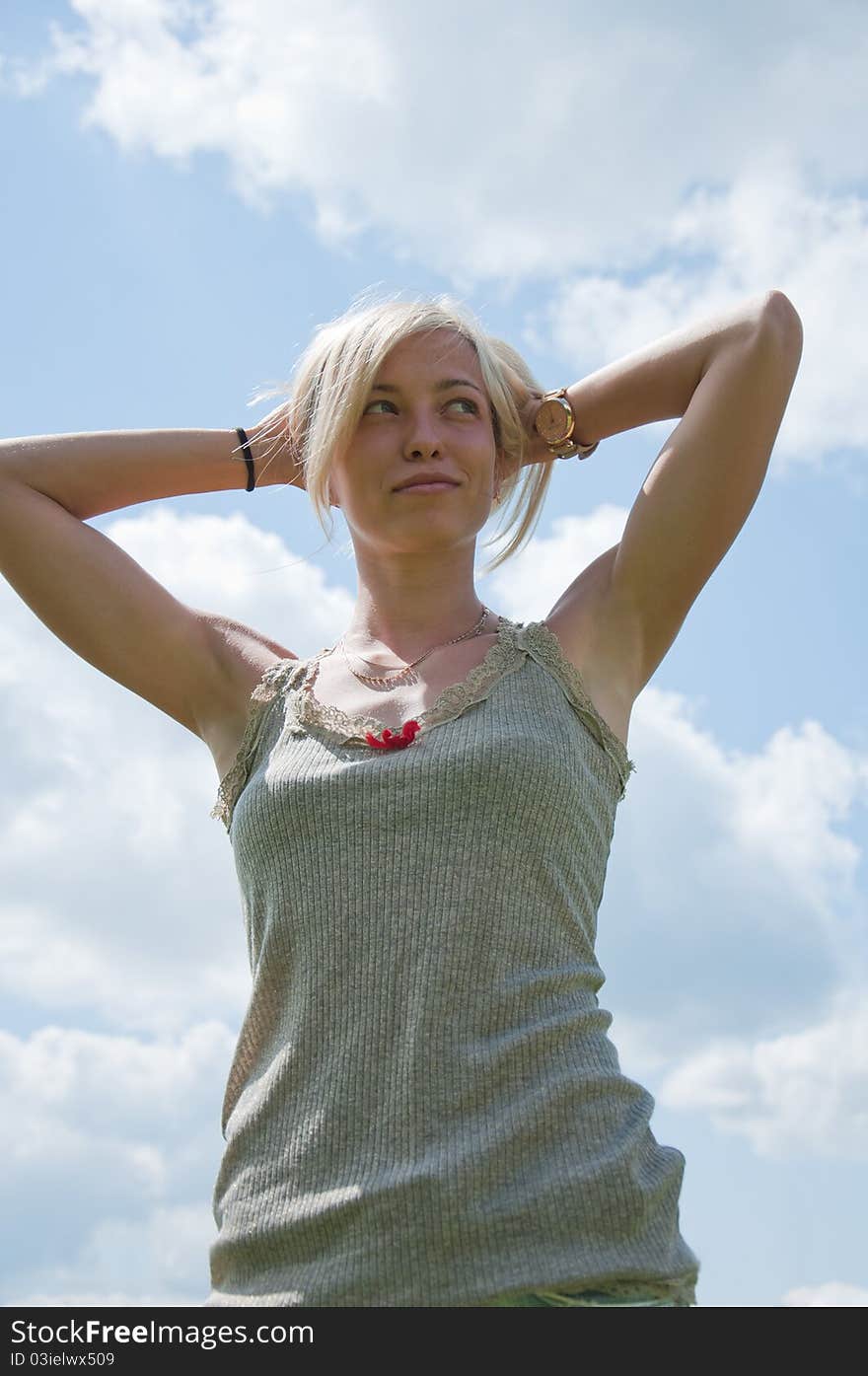 A young athletic girl against the sky