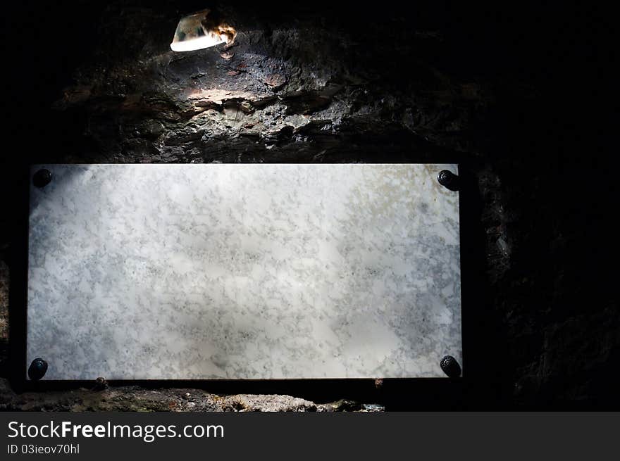 Marble sign enlighted by lamp in cave