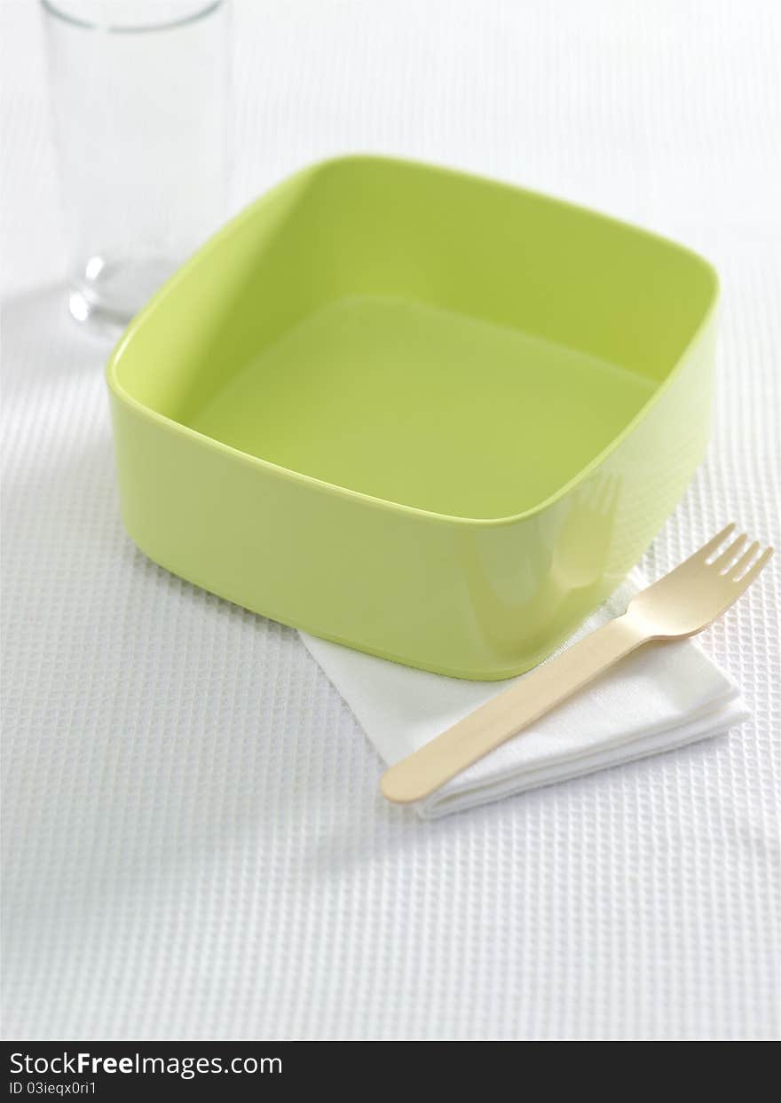 Green bowl with fork and napkin