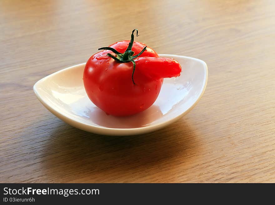 Red tomato on a white plate