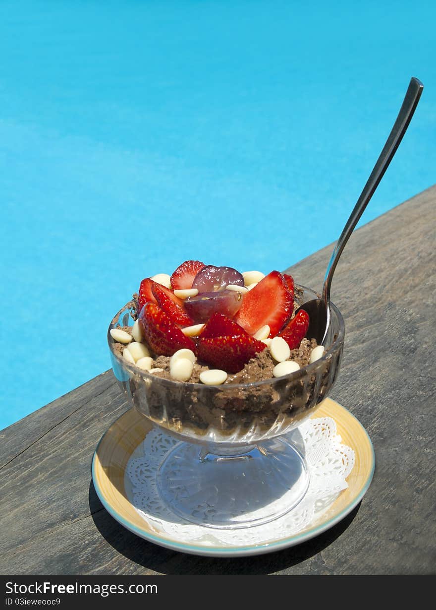 Delicious dessert with chocolate and strawberry near swimming pool