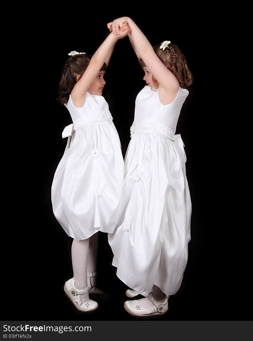 Playful twin sisters with hands joined in the air