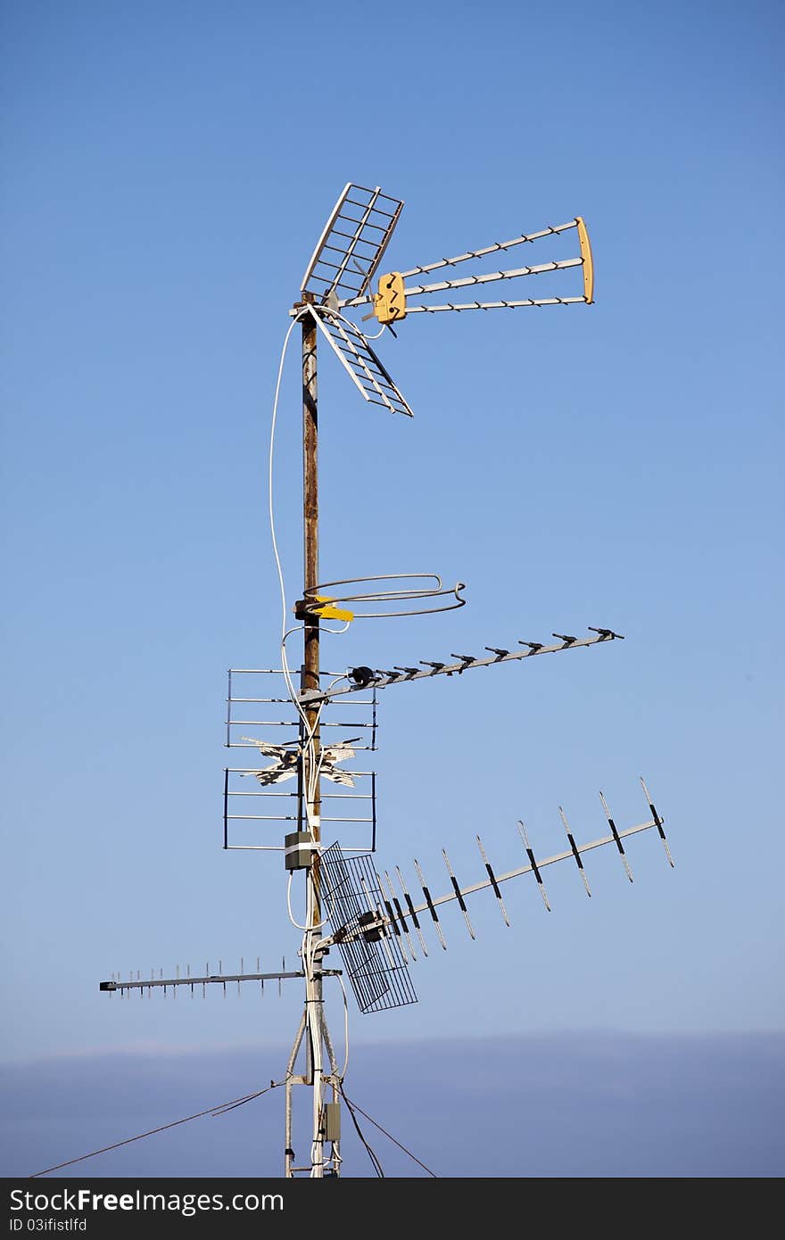 Multiple TV aerials against a blue sky