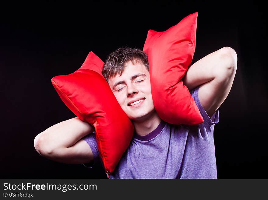 Man sleeping between two pillows in studio