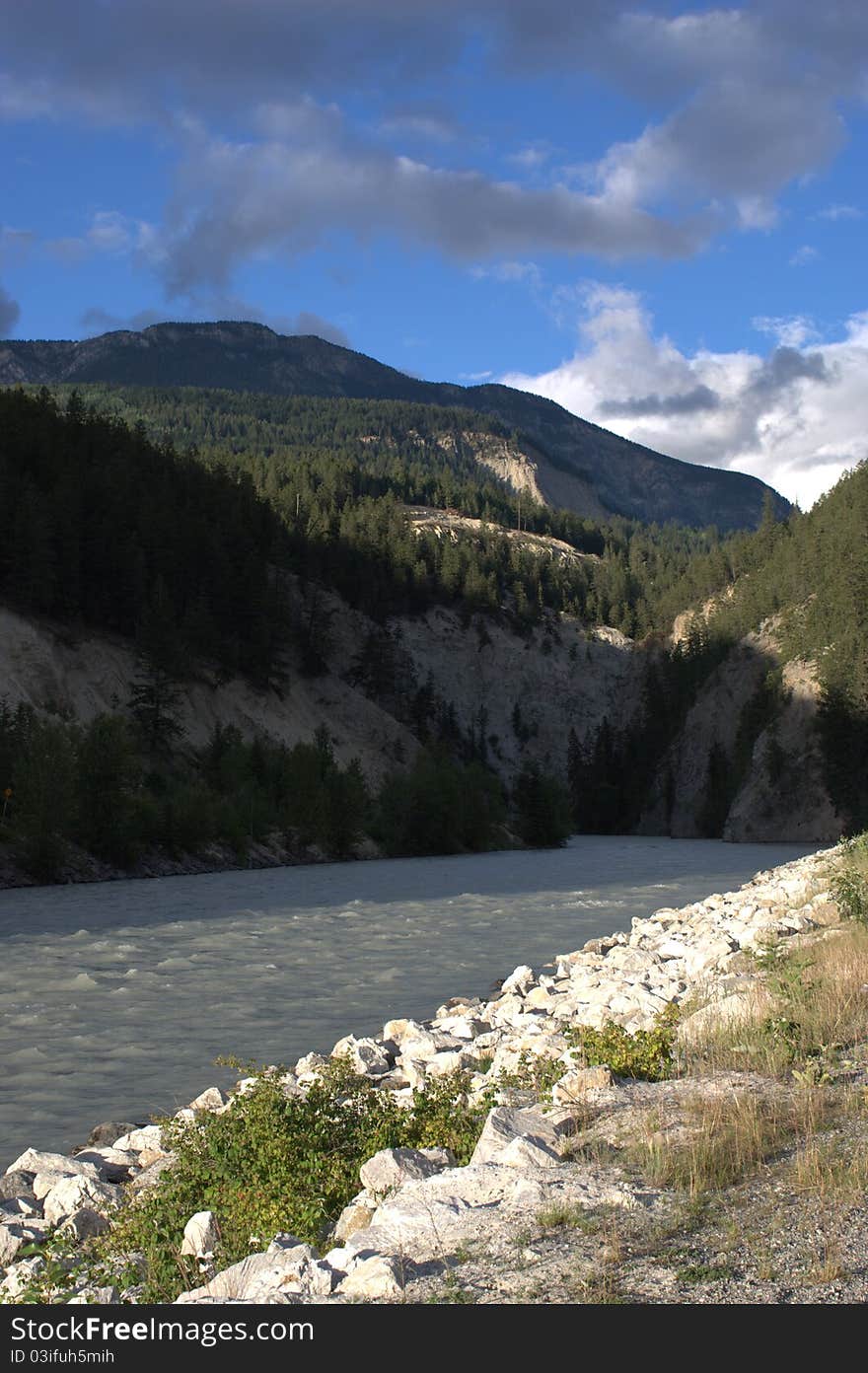 Golden, British Columbia showing mountain, milky river, and rocky shore. Golden, British Columbia showing mountain, milky river, and rocky shore