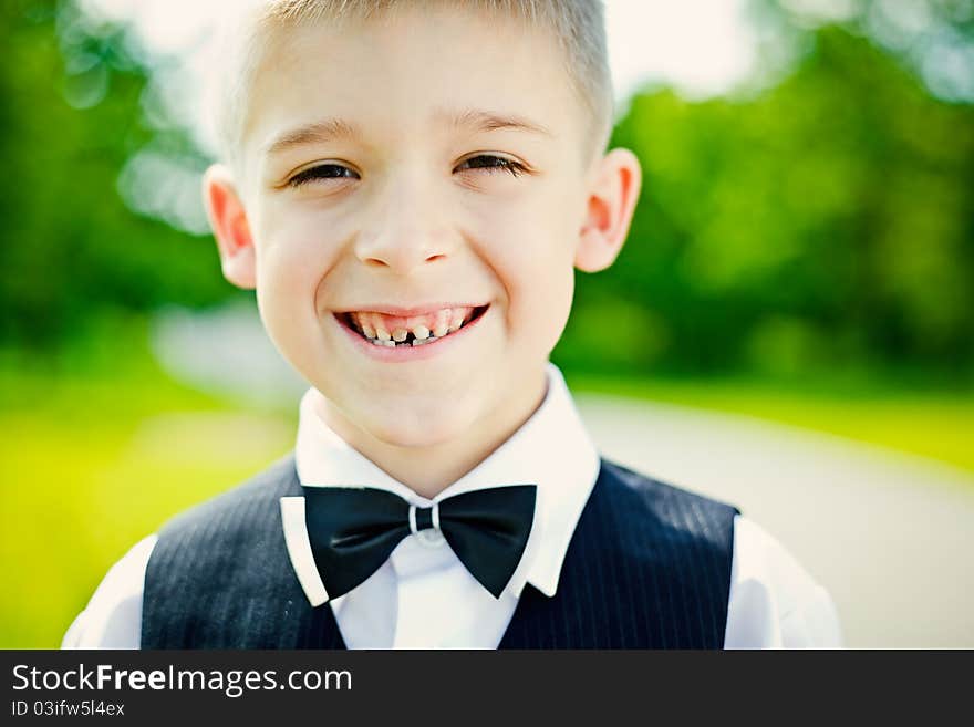 Little boy in a shirt and vest in park