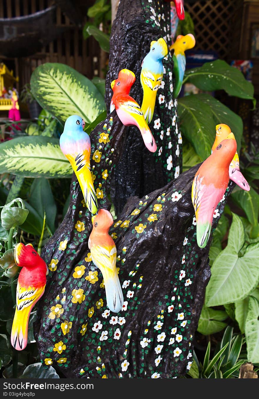 Beautiful ceramic bird clinging to a tree stump flower. Beautiful ceramic bird clinging to a tree stump flower.