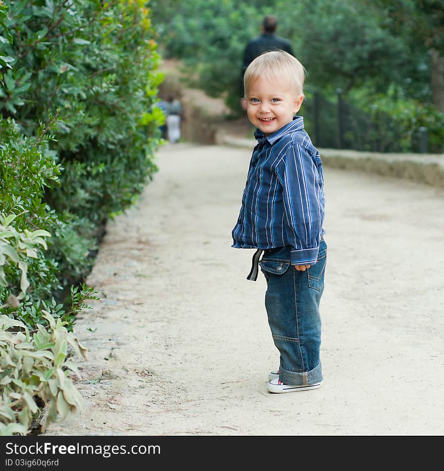 Cute 2 years old boy standing on the footpath in the park. Cute 2 years old boy standing on the footpath in the park