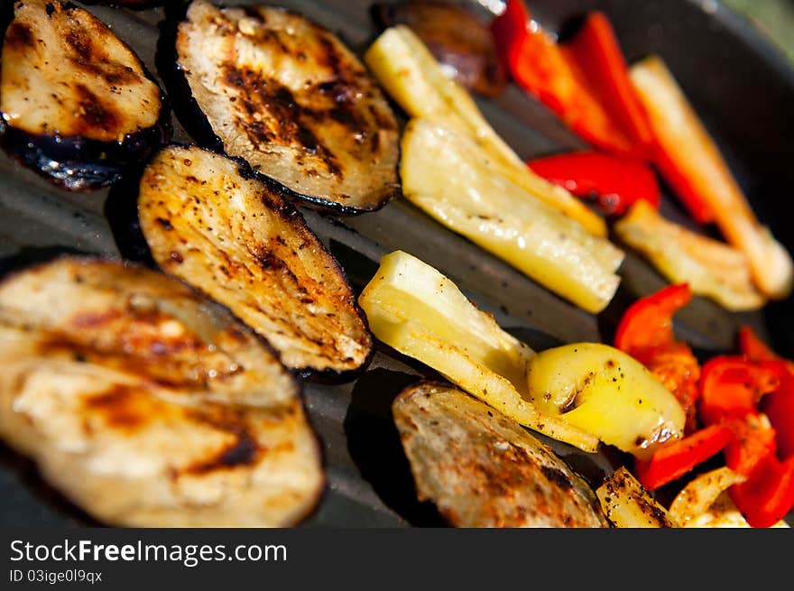 Grilled peppers and eggplants on a griddle.