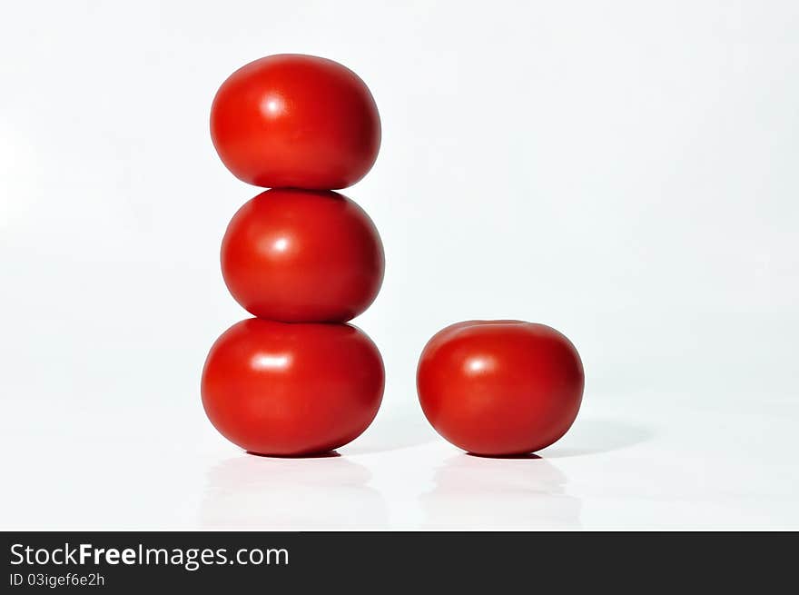 Four tomatoes on a white background in a tower.