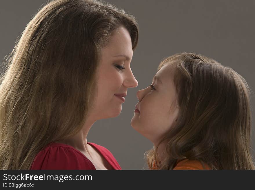 Mum and daughter sit at table and read book. Mum and daughter sit at table and read book