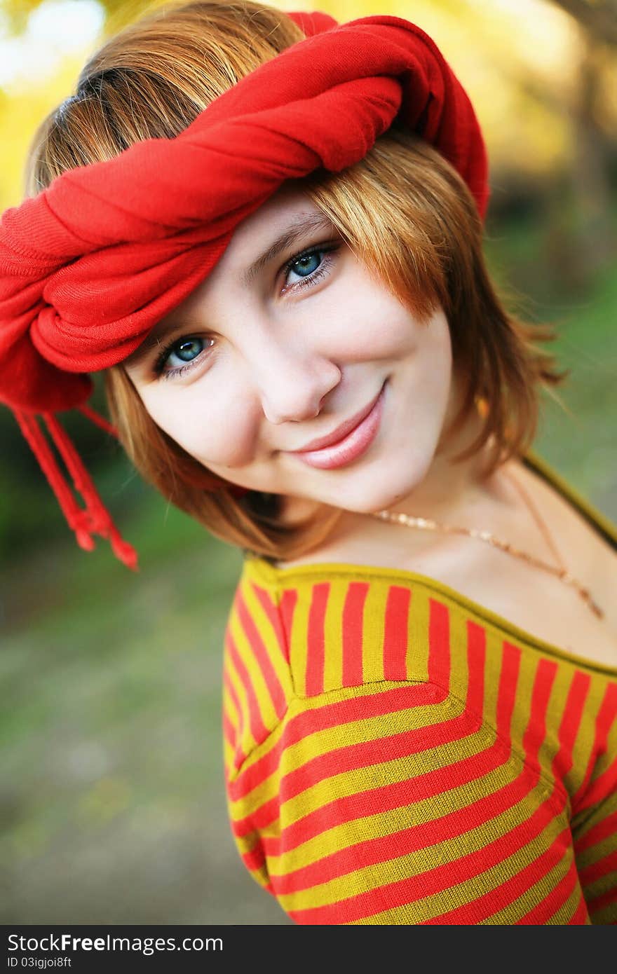 Portrait of a girl in a bright colored striped sweater lying on the grass. Portrait of a girl in a bright colored striped sweater lying on the grass