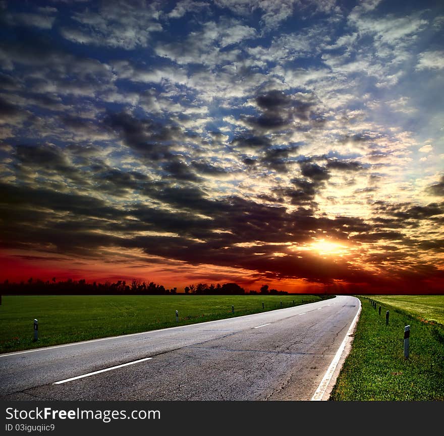 Country road among fields on the skyline