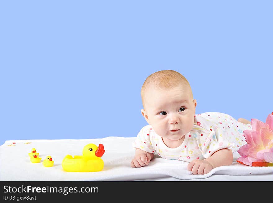 A baby with yellow toy duck and ducklings isolated on the blue background