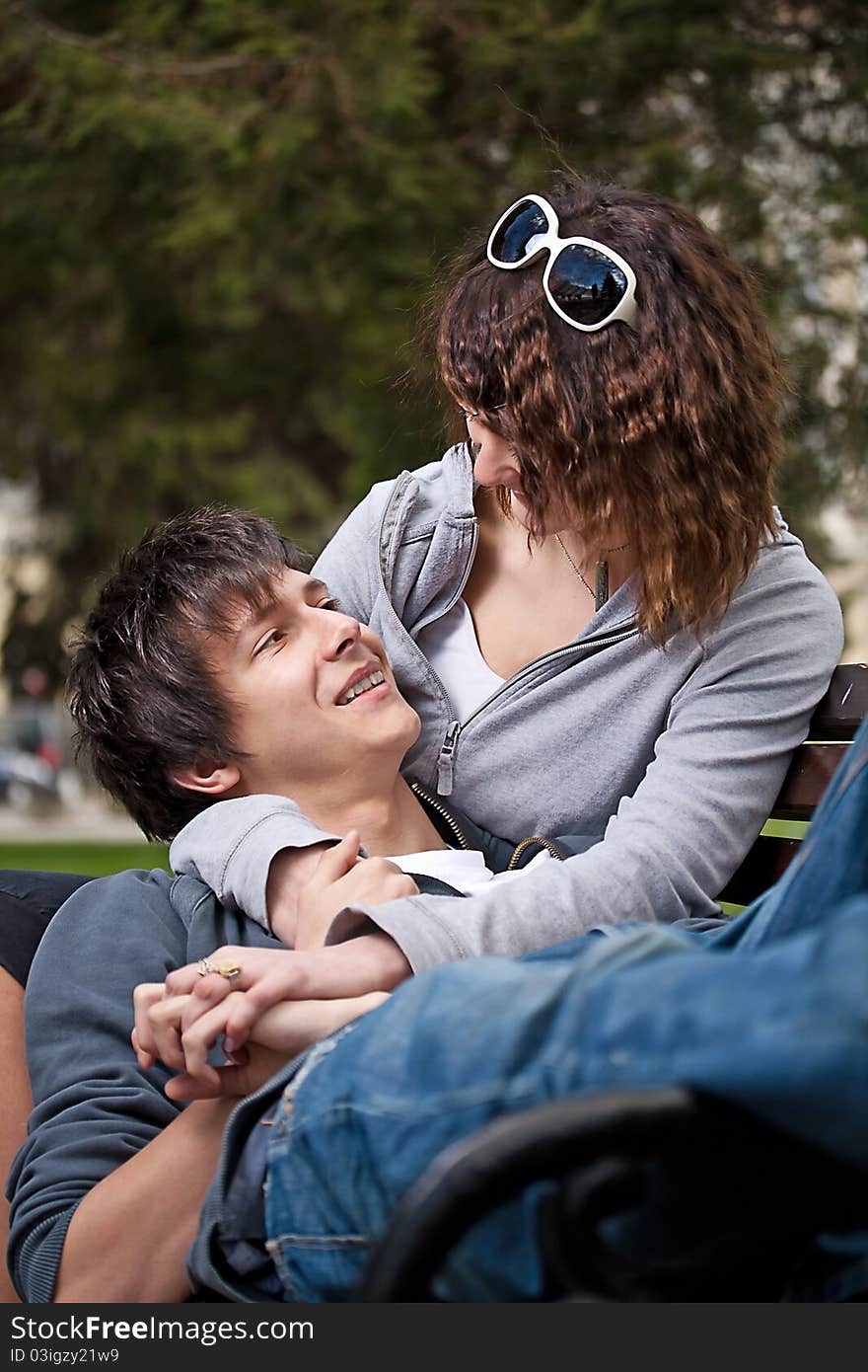 Attractive couple sitting on bench in the park