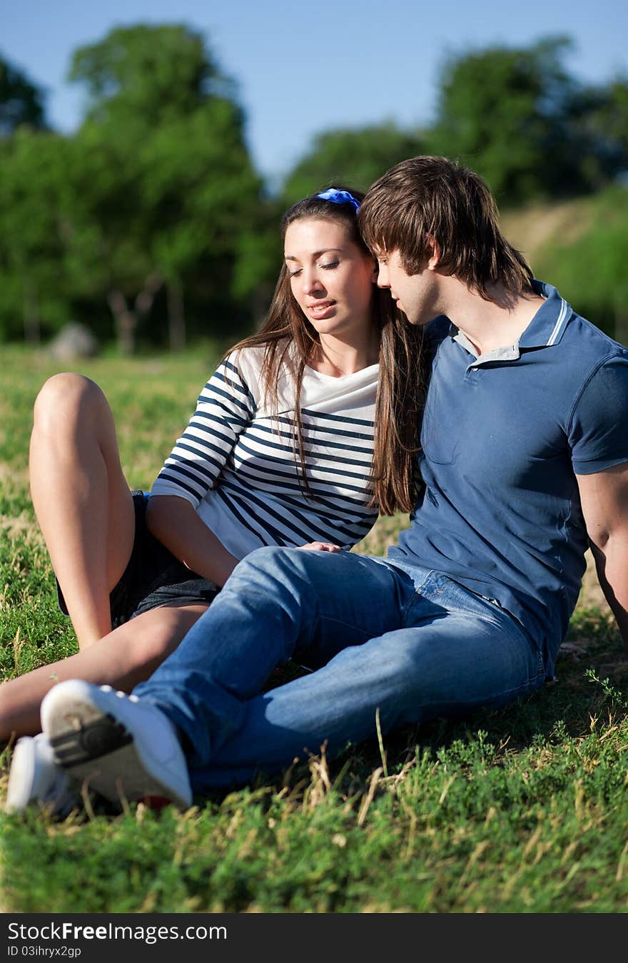 Young pair, men and women relax in park. Young pair, men and women relax in park