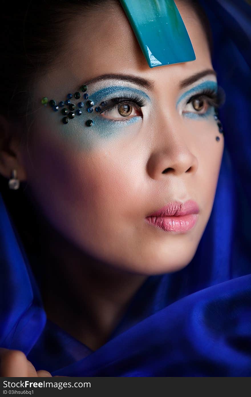 Young beautiful Asian woman in a blue veil posing with makeup