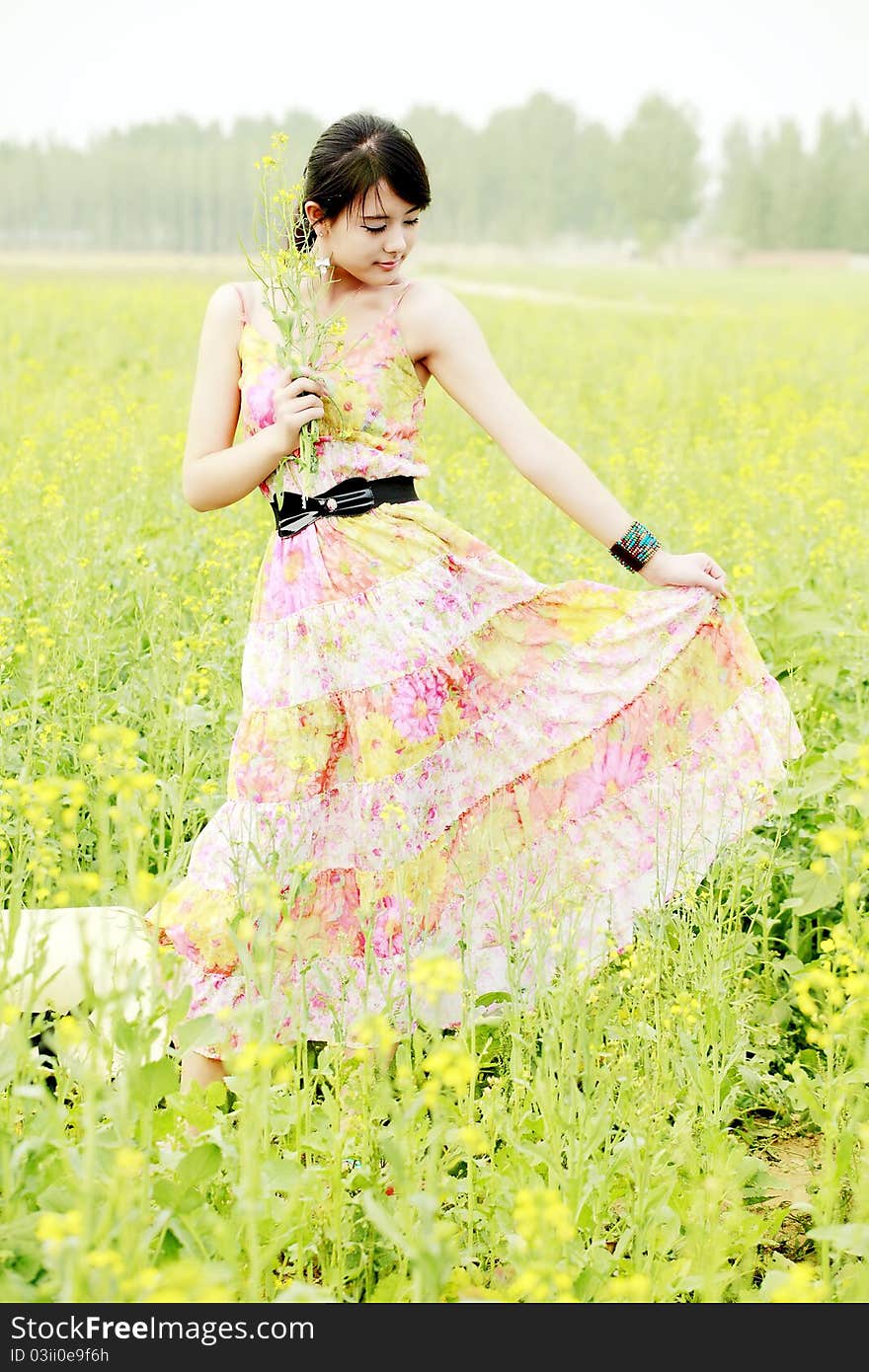 Chinese girl holding a bunch of rape flowers in rape field. Chinese girl holding a bunch of rape flowers in rape field.