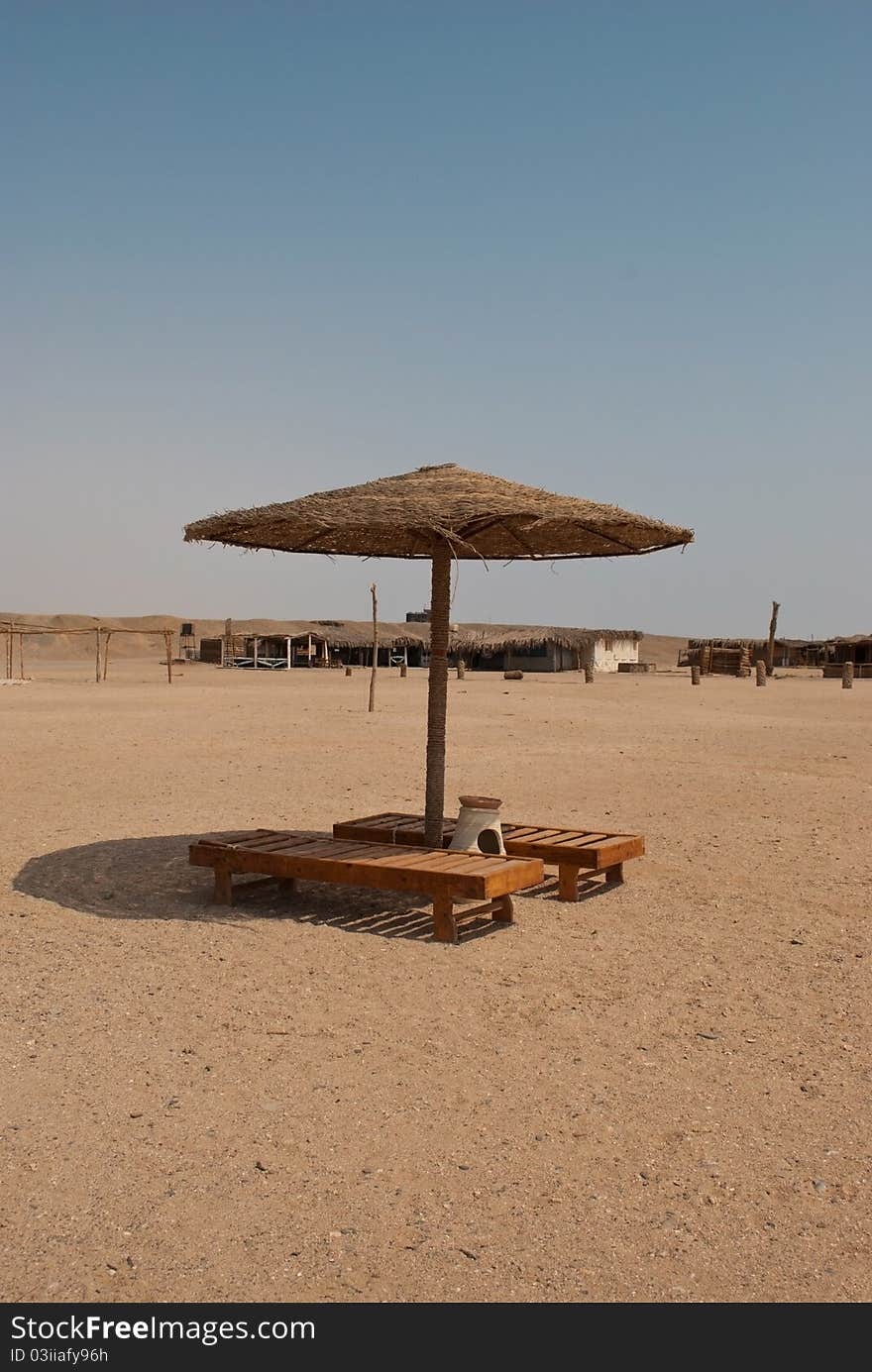 Beach with parasoles and two sunbed